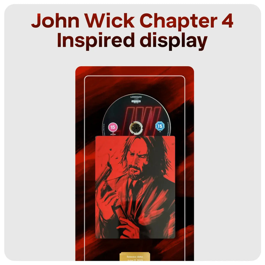 A John Wick Chapter 4 inspired display featuring red and black artwork and plaque with an illustration of John Wick holding a gun, a circular black disc with, and a small gold plaque at the bottom, centered on a light gray background with the text 'John Wick Chapter 4 Inspired display' above it.