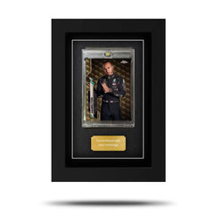 A framed Topps Formula 1 trading card displayed in a clear plastic slipcase within a black frame, with a gold name plate below the card. A framed Topps Formula 1 trading card displayed in a clear plastic slipcase within a black frame, with a gold name plate below the card.