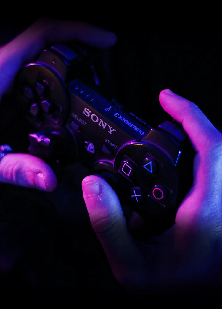 A man plays playstation 2 using a controller