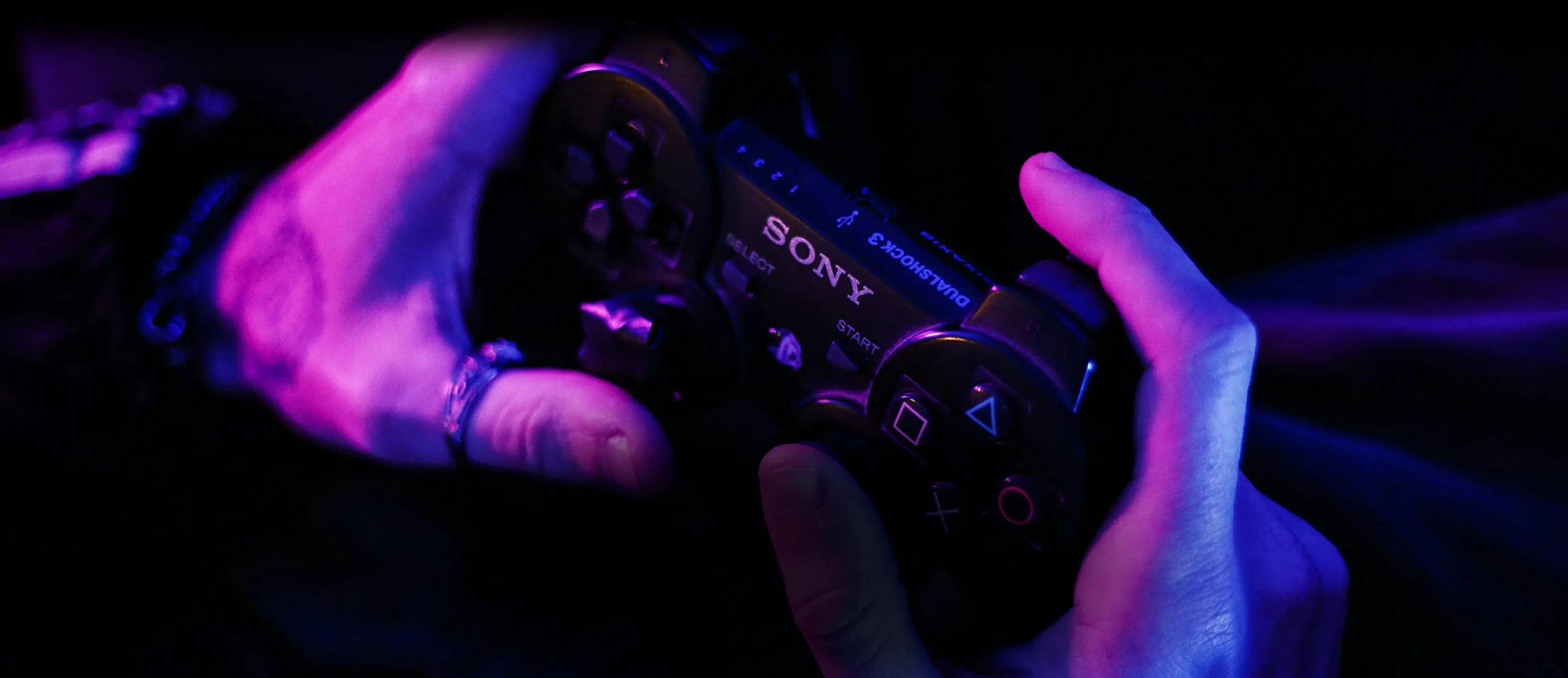 A man plays playstation 2 using a controller, close up