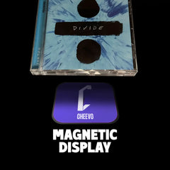 CD jewelled case and disc with 'Divide' text and a purple magnetic display labeled 'Cheevo' on a black background.