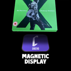 Green album in a cardboard sleeve box set with a person holding a guitar, featuring 'Cheevo' magnetic display on a black background.