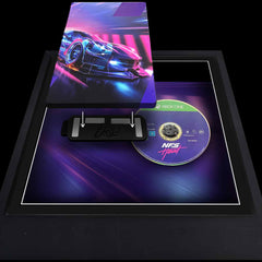 Need For Speed Heat video game case being added to a magnetic bracket inside of a picture frame. The game disc is to the side, ready to be displayed.