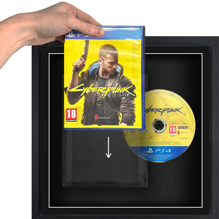 A person holding a Playstation 4 (PS4) video games sliding it into a plastic protective case, in a frame.