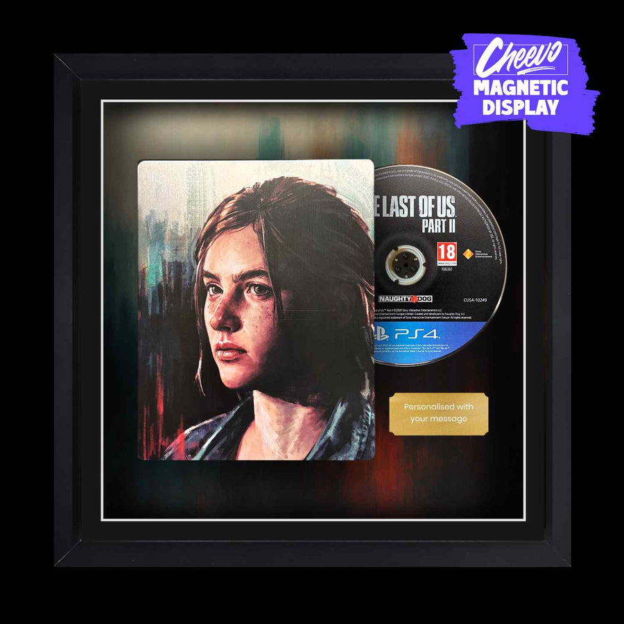 The Last Of Us Part 2 being displayed within a picture frame. The steelbook video game case and disc are next to each other alongside a gold metal plaque
