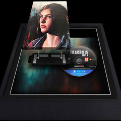 The Last of Us Part 2 video game being added to a square picture frame. The steelbook vase and disc sit side-by-side and are being attached magnetically