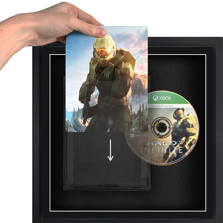 A person holding a Xbox Series X video games sliding it into a plastic protective case, in a frame.