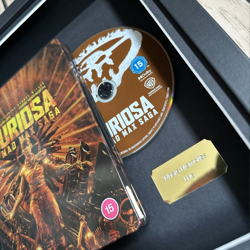 Max Max Saga Furiosa steelbook inside of a picture frame from Cheevo ltd, displayed using magnets