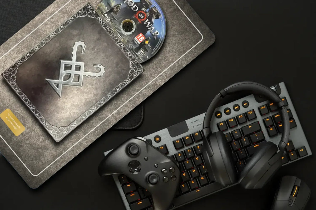 A portrait plate of God of war shown on a black desk alongside gaming accessories including a keyboard, headset, controller, and mouse.