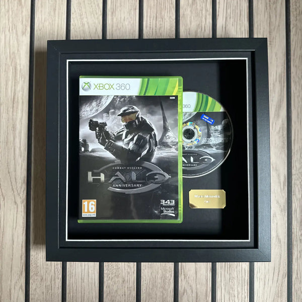A black deep picture frame with Halo Combat Evolved anniversary displayed next to the disc and a gold plaque