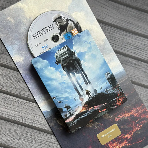 Star Wars Battlefront SteelBook case with the Blu-ray disc partially slid out, placed on a gray wood plank surface. 