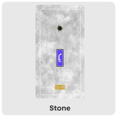 A rectangular wall-mounted panel in a stone texture finish, shown against a light grey background. The panel has a faux concrete look with a small circular opening near the top, a blue-and-white Cheevo icon in the center, and a small gold label near the bottom.