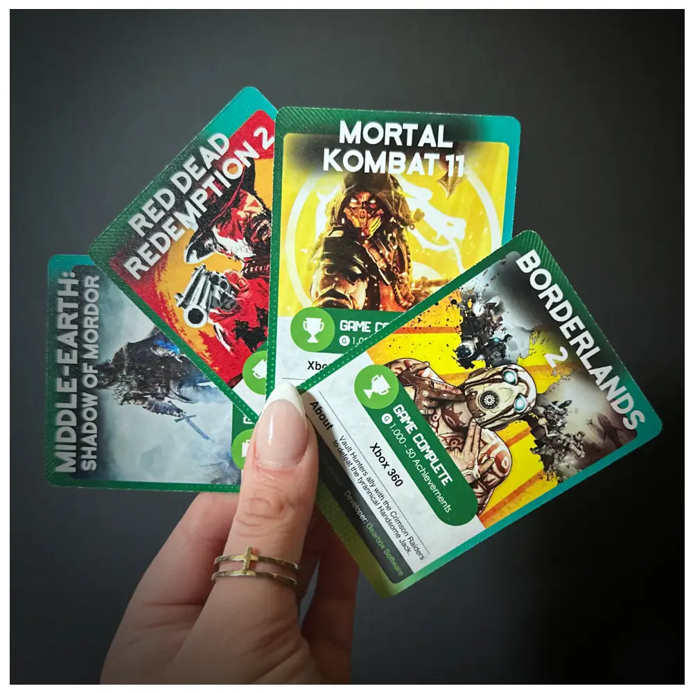 Four Xbox achievement collector cards for 'Middle-earth: Shadow of Mordor', 'Red Dead Redemption 2', 'Mortal Kombat 11', and 'Borderlands 2', printed on both sides showing full game completion achievements